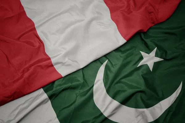 Agitant le drapeau coloré du pakistan et le drapeau national du Pérou . — Photo