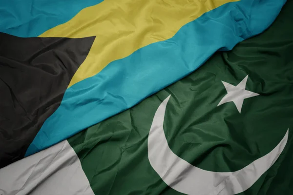 Ondeando colorida bandera de Pakistán y bandera nacional de Bahamas . — Foto de Stock