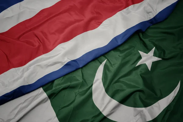 Zwaaiende kleurrijke vlag van Pakistan en de nationale vlag van Costa Rica. — Stockfoto