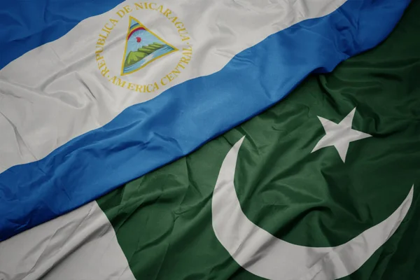 Waving colorful flag of pakistan and national flag of nicaragua. — Stock Photo, Image