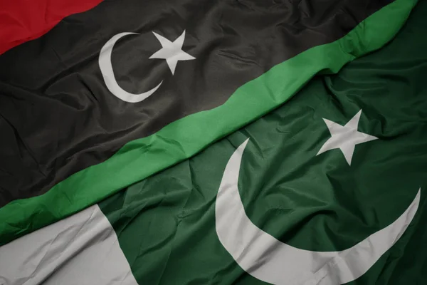 Pakistan ve libya ulusal bayrağı renkli bayrak sallayarak. — Stok fotoğraf