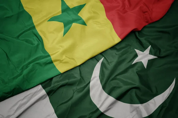 Waving colorful flag of pakistan and national flag of senegal. — Stock Photo, Image