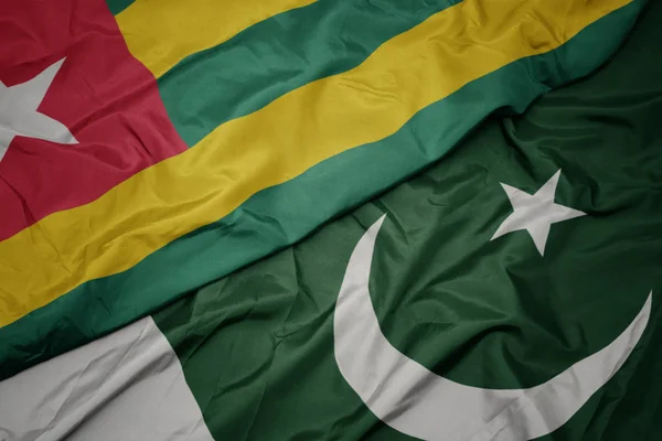 Ondeando colorida bandera de Pakistán y bandera nacional de Togo . — Foto de Stock