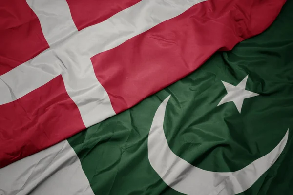 Agitant le drapeau coloré du pakistan et le drapeau national du Danemark . — Photo
