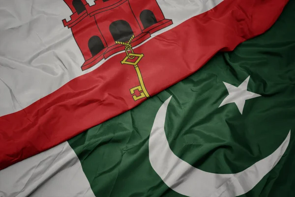 Waving colorful flag of pakistan and national flag of gibraltar. — Stock Photo, Image