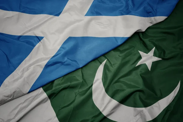 Agitant le drapeau coloré du pakistan et le drapeau national de l'Écosse . — Photo