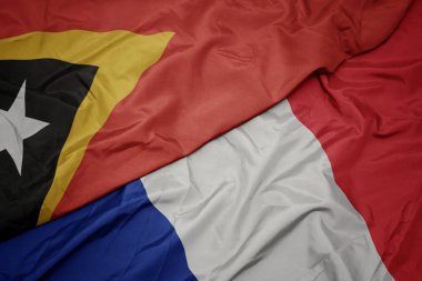 fransa ve doğu timor ulusal bayrağı renkli bayrak sallayarak.