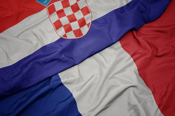 Agitant drapeau coloré de la france et drapeau national de la croatie . — Photo