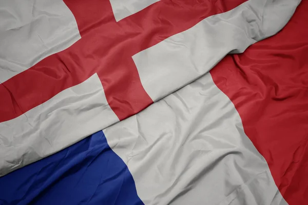 Zwaaiende kleurrijke vlag van Frankrijk en de nationale vlag van Engeland. — Stockfoto