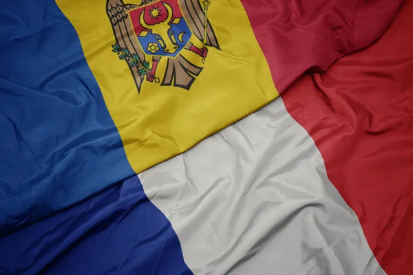 Ondeando colorida bandera de Francia y bandera nacional de Moldavia . —  Fotos de Stock