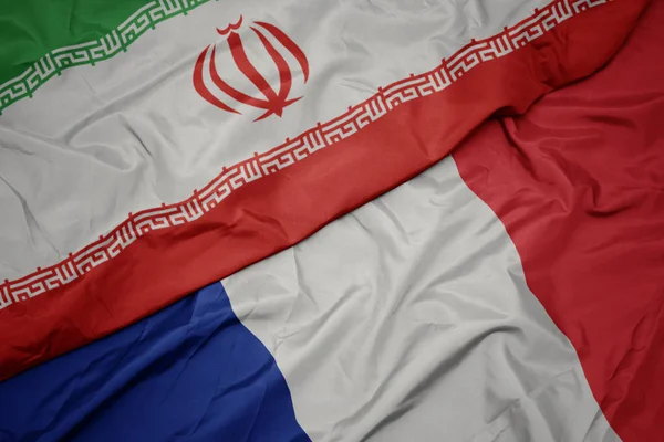 Размахивая красочным флагом Франции и национальным флагом Ирана . — стоковое фото