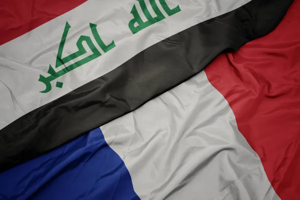 Sventolando bandiera colorata della Francia e bandiera nazionale dell'Iraq . — Foto Stock