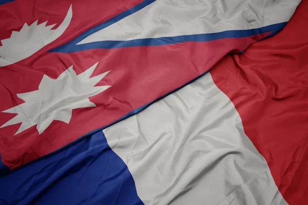Размахивая красочным флагом Франции и национальным флагом Непала . — стоковое фото