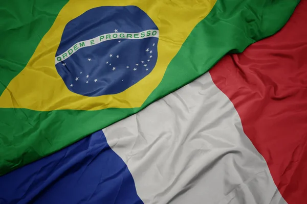 Ondeando colorida bandera de Francia y bandera nacional de Brasil . — Foto de Stock