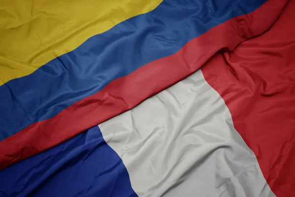 Ondeando colorida bandera de Francia y bandera nacional de Colombia . —  Fotos de Stock