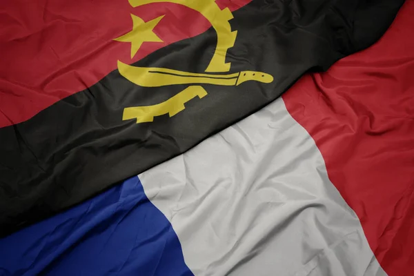 Waving colorful flag of france and national flag of angola. — Stock Photo, Image