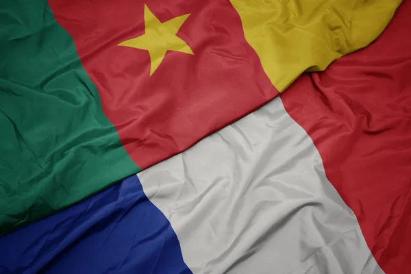 Zwaaiende kleurrijke vlag van Frankrijk en de nationale vlag van Kameroen. — Stockfoto