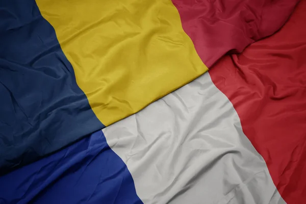 Zwaaiende kleurrijke vlag van Frankrijk en de nationale vlag van Tsjaad. — Stockfoto