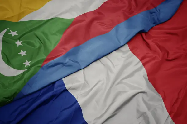 Ondeando colorida bandera de Francia y bandera nacional de las comoras . — Foto de Stock