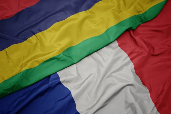 Ondeando colorida bandera de Francia y bandera nacional de Mauricio . — Foto de Stock
