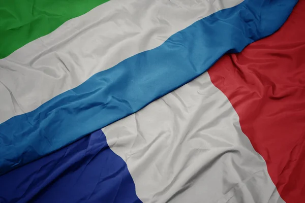 Mávající vlajka Francie a národní vlajka Sierry Leone. — Stock fotografie