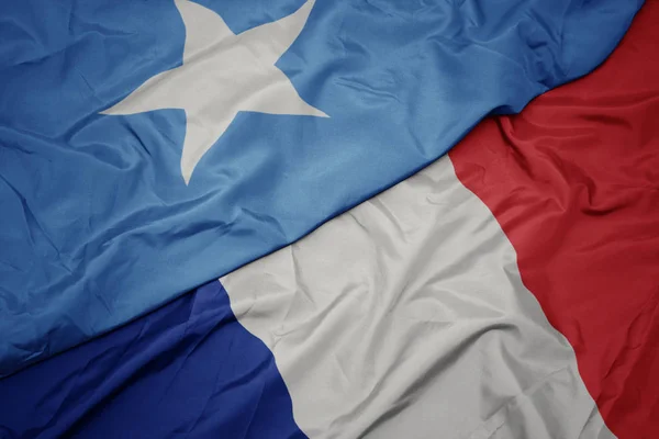 Acenando bandeira colorida da frança e bandeira nacional da somália . — Fotografia de Stock