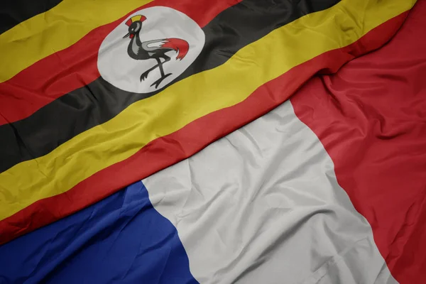 Размахивая красочным флагом Франции и национальным флагом Уганды . — стоковое фото