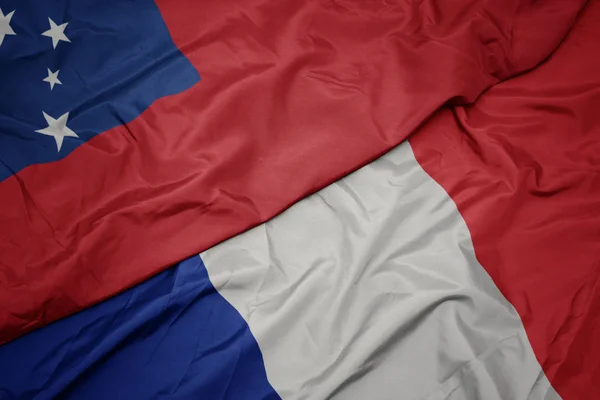 Agitant le drapeau coloré de la France et le drapeau national des Samoa  ,. — Photo