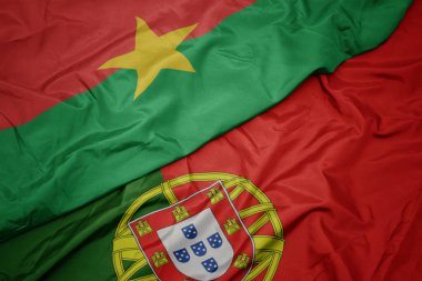 portekiz renkli bayrak ve burkina faso ulusal bayrağı sallayarak.