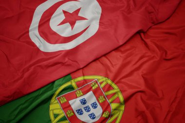 portekiz ve tunus ulusal bayrağı renkli bayrak sallayarak.