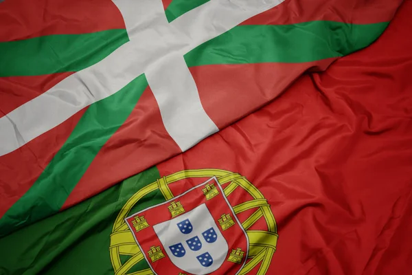 Falujące kolorowe flagi Portugalii i flagi narodowej kraju Basków. — Zdjęcie stockowe