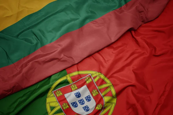 Размахивая красочным флагом Португалии и национального флага Литвы . — стоковое фото
