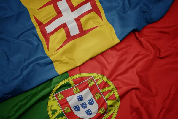 Размахивая красочным флагом Португалии и национального флага Мадейры . — стоковое фото