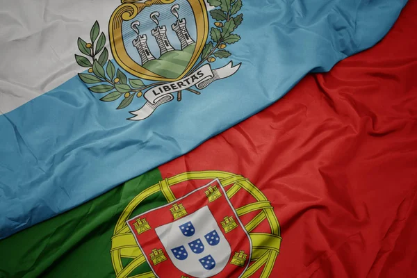 portekiz renkli bayrak ve san marino ulusal bayrağı sallayarak.