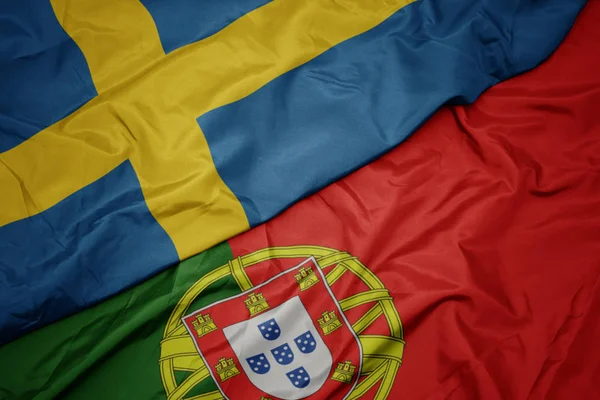 Размахивая красочным флагом Португалии и национального флага Швеции . — стоковое фото