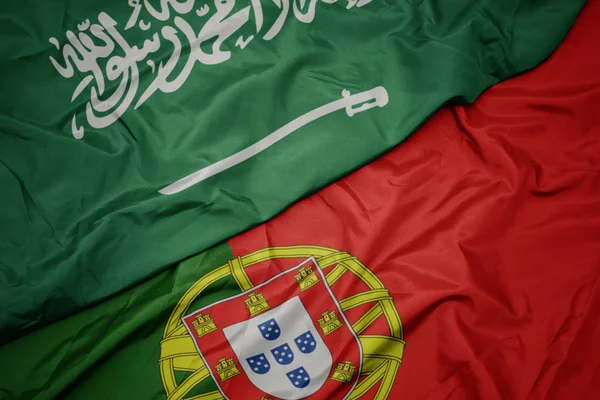ポルトガルのカラフルな旗とサウジアラビアの国旗を振る. — ストック写真