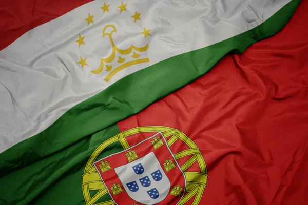 portekiz renkli bayrak ve tacikistan ulusal bayrağı sallayarak.