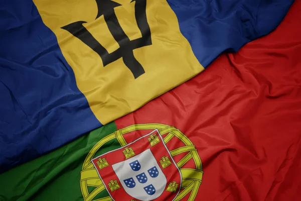 Mávající barvitá vlajka Portugalska a státní vlajka Barbadosu. — Stock fotografie