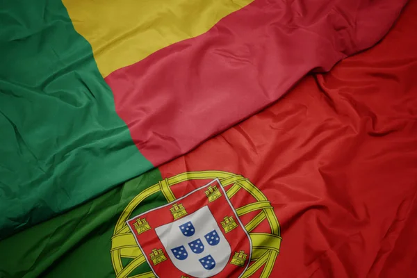 portekiz ve benin ulusal bayrağı renkli bayrak sallayarak.