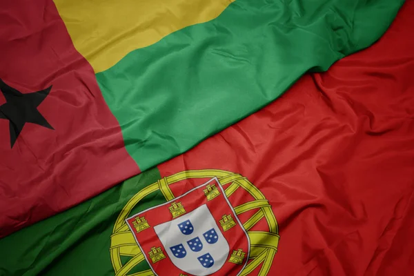 portekiz ve gine bissau ulusal bayrağı renkli bayrak sallayarak.