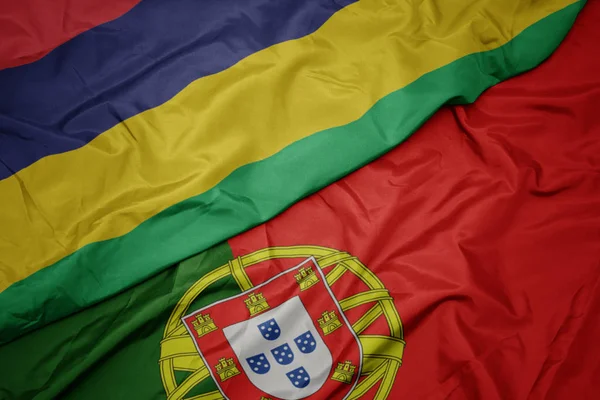 Размахивая красочным флагом Португалии и национального флага Маврикия . — стоковое фото