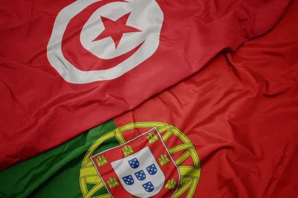 portekiz ve tunus ulusal bayrağı renkli bayrak sallayarak.