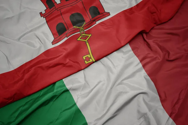 Sventolando bandiera colorata d'Italia e bandiera nazionale di gibraltar . — Foto Stock