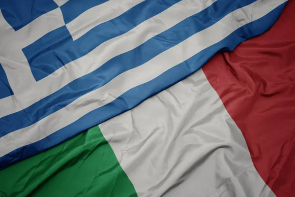 Schwenken bunte Flagge Italiens und griechische Nationalflagge. — Stockfoto