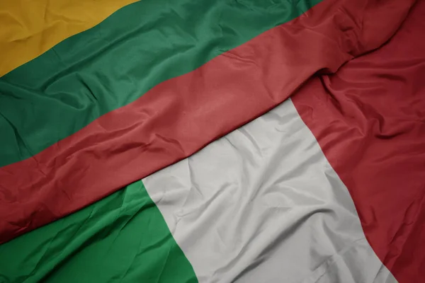 Ondeando colorida bandera de italia y bandera nacional de lituanía . — Foto de Stock