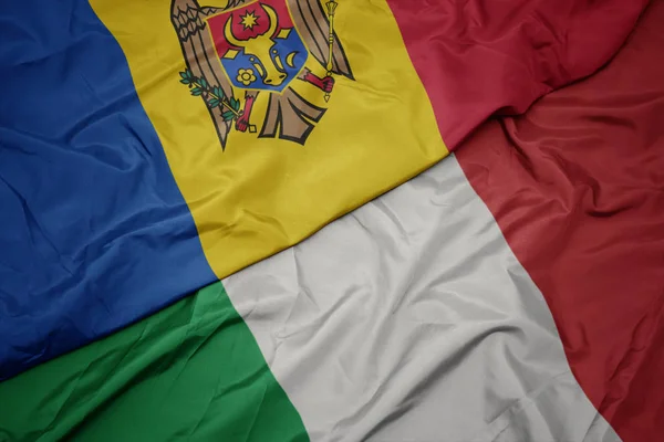 Ondeando colorida bandera de italia y bandera nacional de moldavia . —  Fotos de Stock