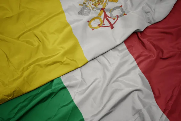 Sventolando bandiera colorata d'Italia e bandiera nazionale della città vaticana . — Foto Stock