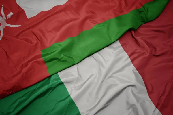 Waving colorful flag of italy and national flag of oman. — Stock Photo, Image