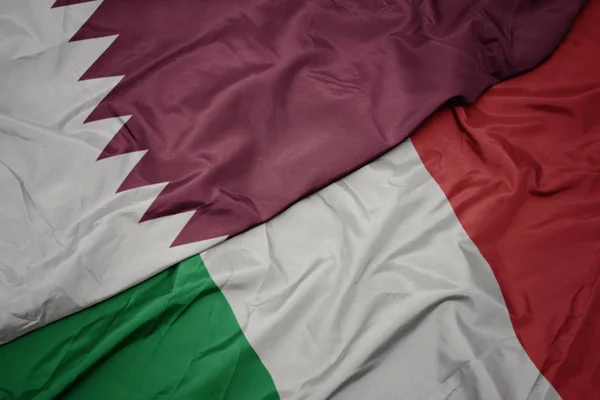 Waving colorful flag of italy and national flag of qatar. — Stock Photo, Image