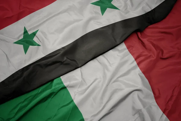 Ondeando colorida bandera de Italia y bandera nacional de Siria . —  Fotos de Stock